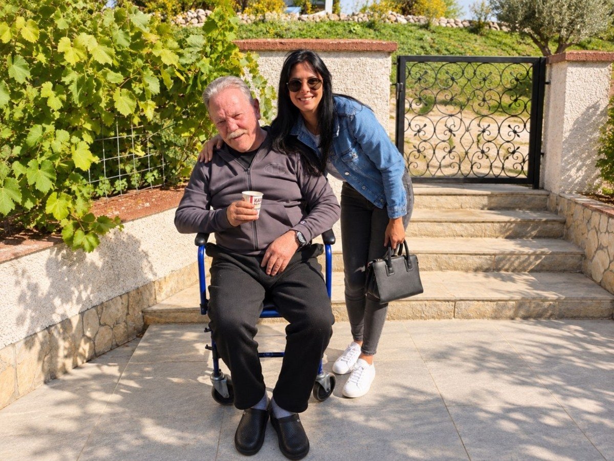 Valentina offering personal support to an elderly wheelchair user
